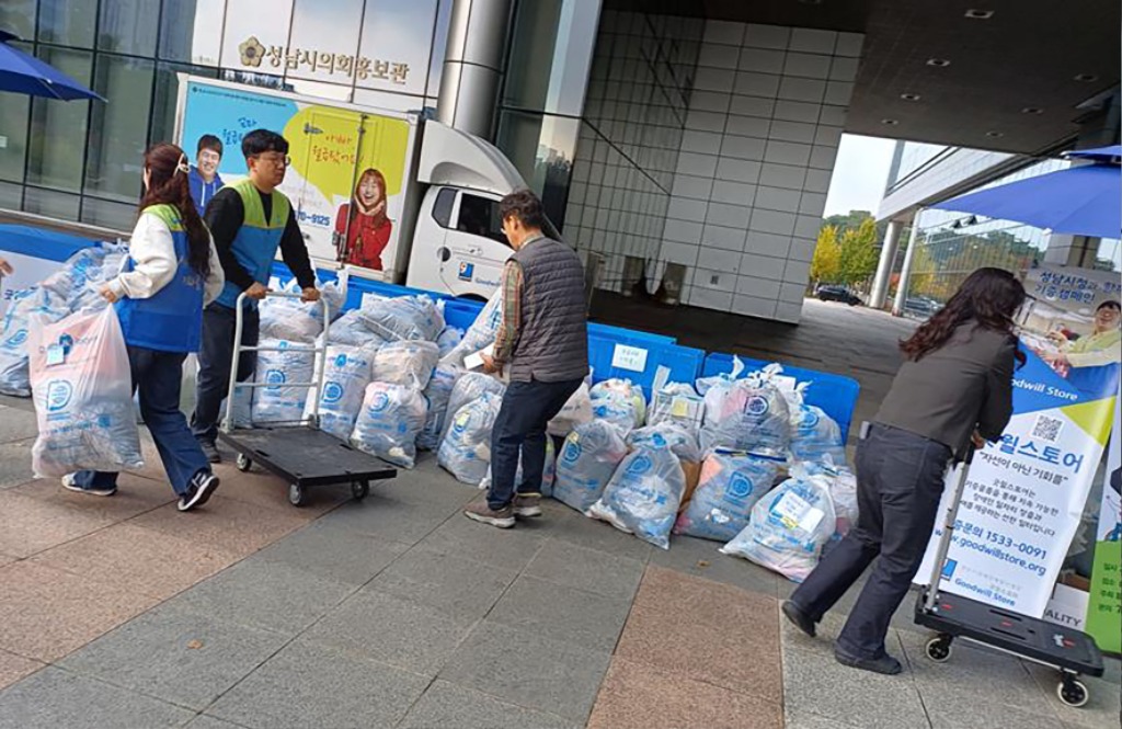 장애인복지과-성남시청 공무원들이 장애인 직업재활시설에 보내기 위해 집 안에 묵혀뒀던 의류·잡화 등을 모아 시청 정문 앞에 쌓고 있다.jpg