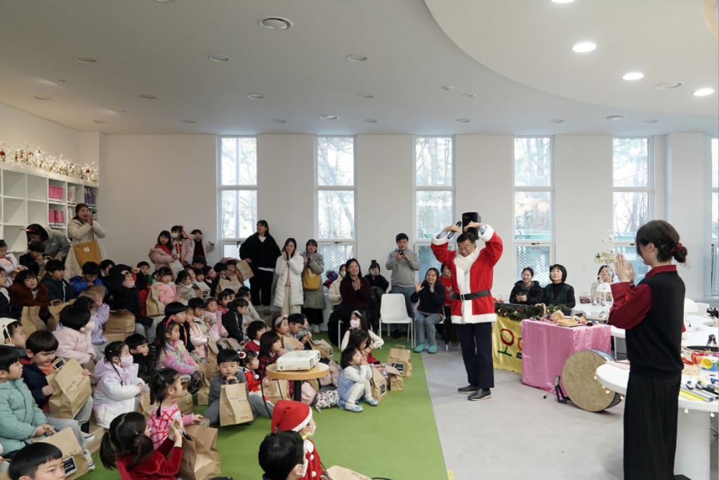 산타로 분장한 신상진 성남시장이 리모델링한 중앙도서관 어린이 자료실을 방문해 뮤지컬 관람 어린이들과 함께 하고 있다.jpg