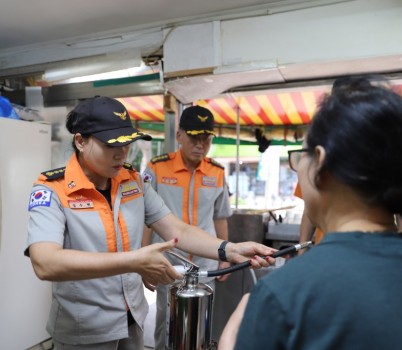 K급 소화기를 배부하고, 사용법을 설명하고 있는 엄수현 경기도 여성 의용소방대 연합회장.JPG width: 100%; height : 150px